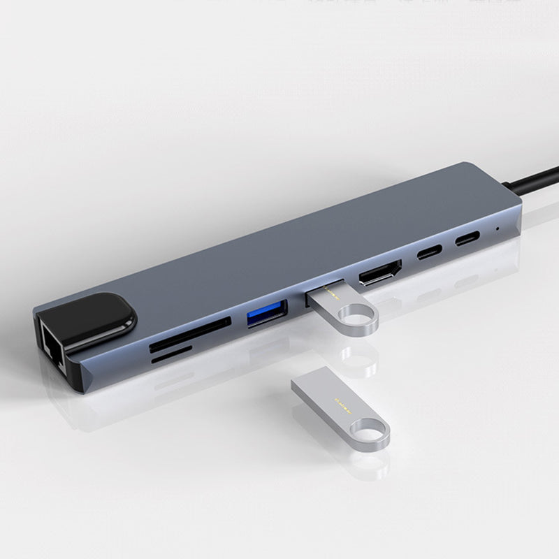 "8 i 1 USB-C dockningsstation i aluminium, modern design med flera portar för effektiv dataöverföring och laddning."
