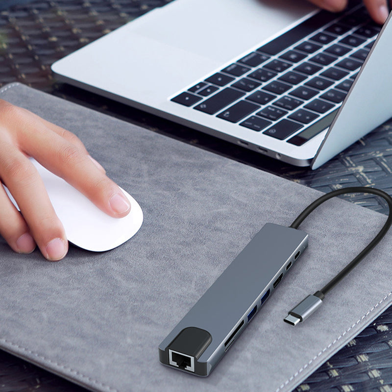 "8 i 1 USB-C dockningsstation i aluminium, modern design med flera portar för effektiv dataöverföring och laddning."