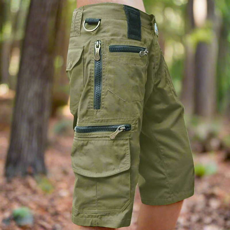 "Avslappnade herr cargo shorts i bomull, flera fickor med dragkedja, grön färg, utomhusbruk, stilren och praktisk design."
