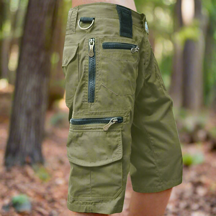 "Avslappnade herr cargo shorts i bomull, flera fickor med dragkedja, grön färg, utomhusbruk, stilren och praktisk design."