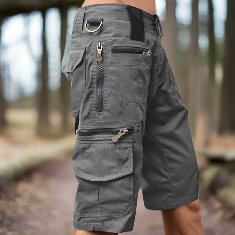 "Avslappnade herr cargo shorts i bomull, flera fickor med dragkedja, grön färg, utomhusbruk, stilren och praktisk design."