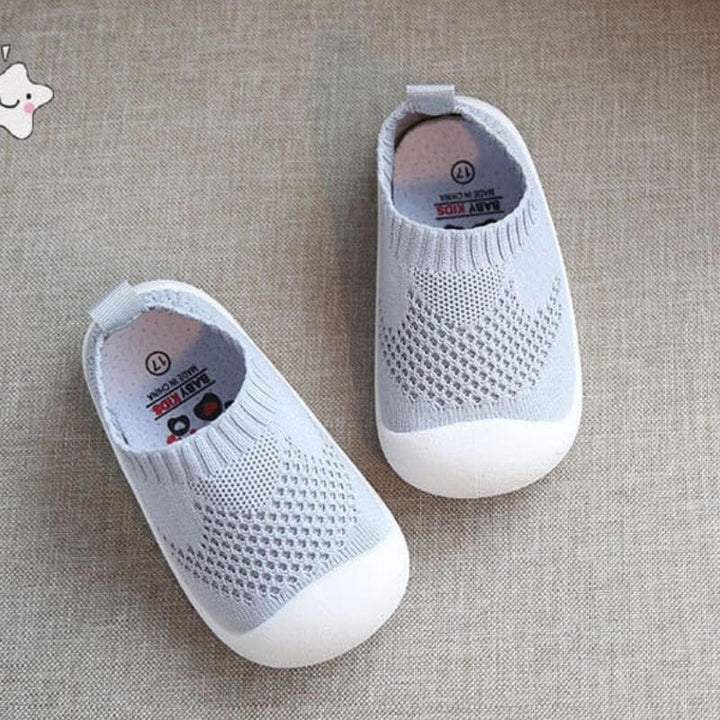 Detaljbild av det andningsbara nätmaterialet på babyskor med halkfri sula.