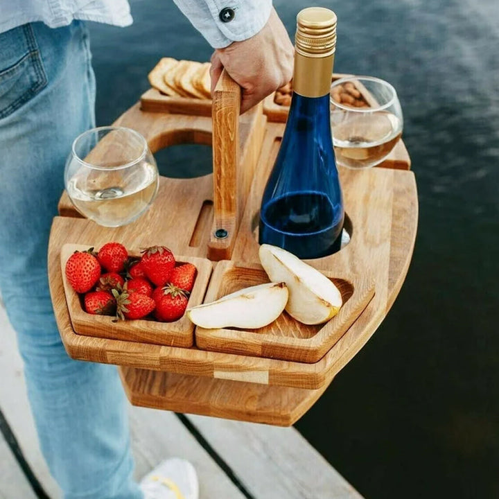 "Bärbart trä picknickbord med flaskhållare och matceller, perfekt för vin och snacks utomhus, naturfärgat och kompakt."
