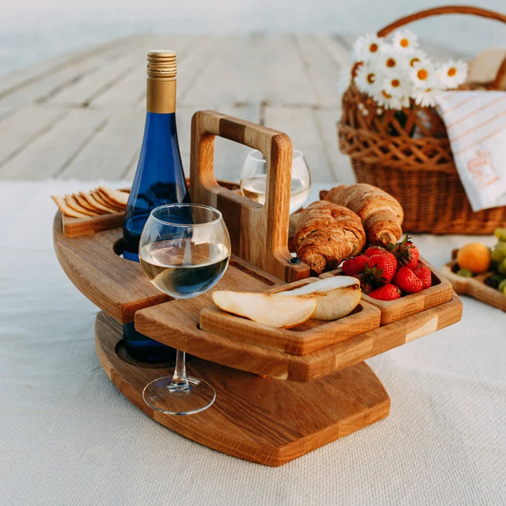 "Bärbart trä picknickbord med flaskhållare och matceller, perfekt för vin och snacks utomhus, naturfärgat och kompakt."