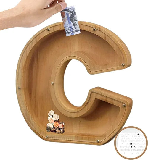 "Barn håller träbokstavs-spargris med glaspanel och bokstavsdesign, perfekt för pedagogisk sparning och inredning."