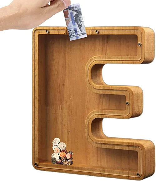 "Barn håller träbokstavs-spargris med glaspanel och bokstavsdesign, perfekt för pedagogisk sparning och inredning."