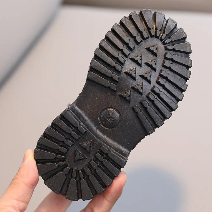 Barnstövlar i PU-läder framifrån, visar den eleganta designen och robusta konstruktionen.