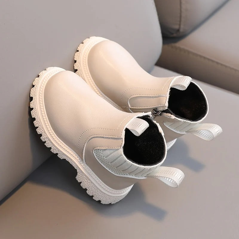 Detaljbild av materialet: högkvalitativt PU-läder på barnstövlarna, hållbara för lek och bus.