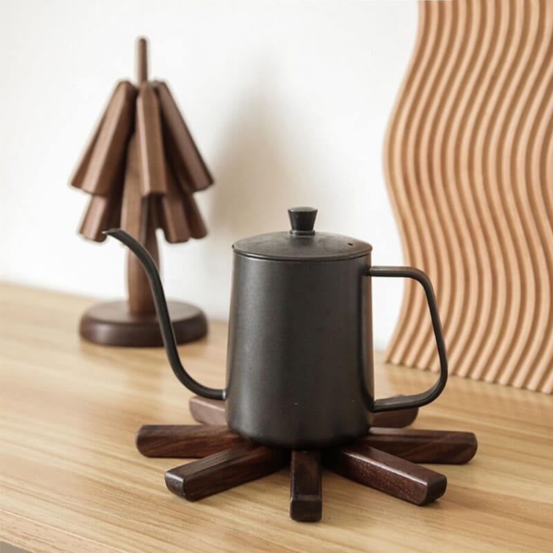 "Bordsmatta i svart valnötsträ, värmeisolerande, elegant design, i köket, hållbar naturprodukt."