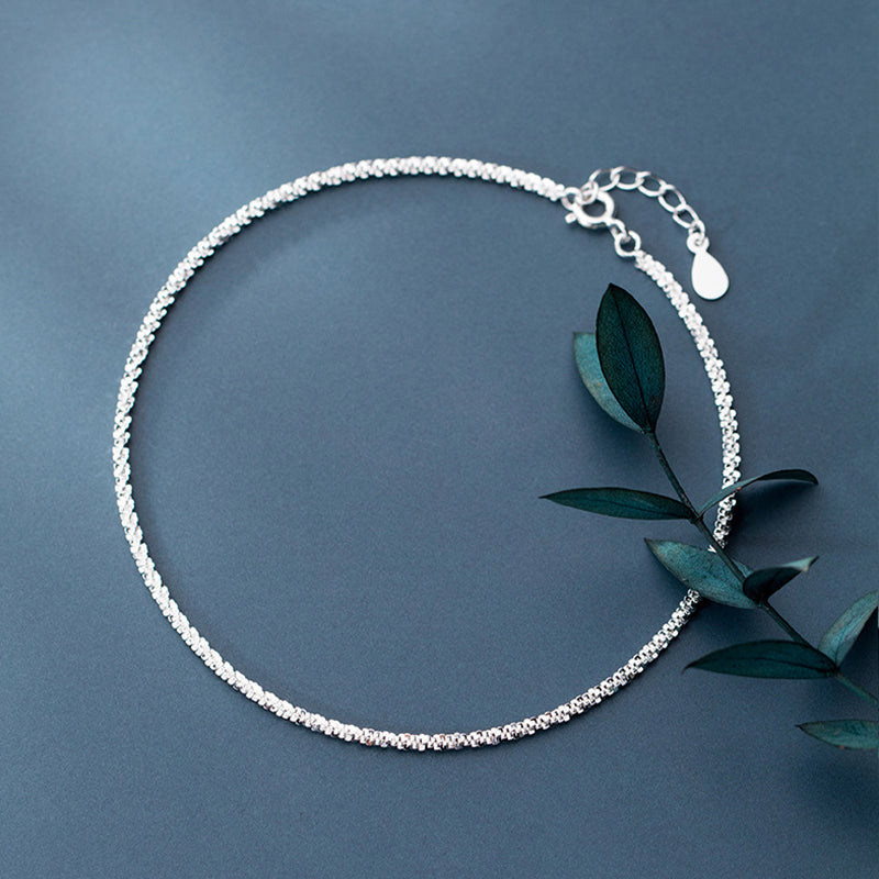 "Dambyxa i glittrande silver med glitterkedja, skimrande design för elegans och stil, perfekt accessoar för kvinnor."