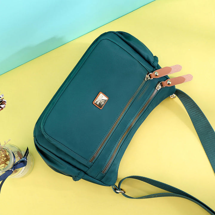 Damkurirväska i nylon med flera fack, stilren och rymlig, perfekt för modern organisering och dagliga behov.