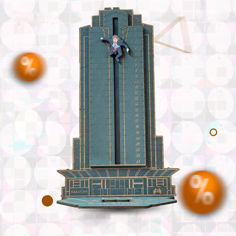 "Detaljerad trä Adventskalender med Die Hard-motiv, visar Hans Gruber faller från brunblå Nakatomi Plaza, roterbar design."