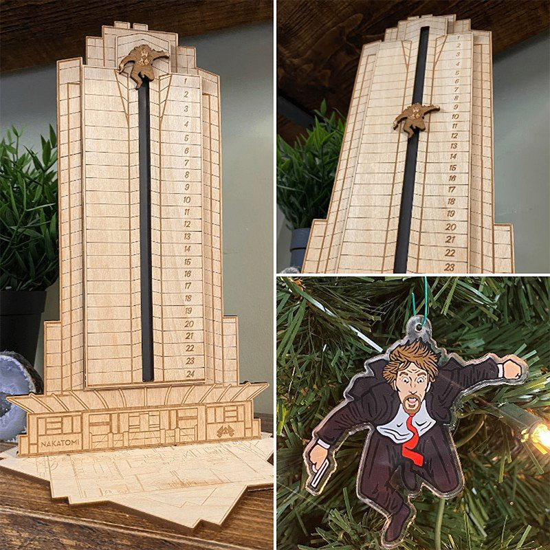 "Detaljerad trä Adventskalender med Die Hard-motiv, visar Hans Gruber faller från brunblå Nakatomi Plaza, roterbar design."