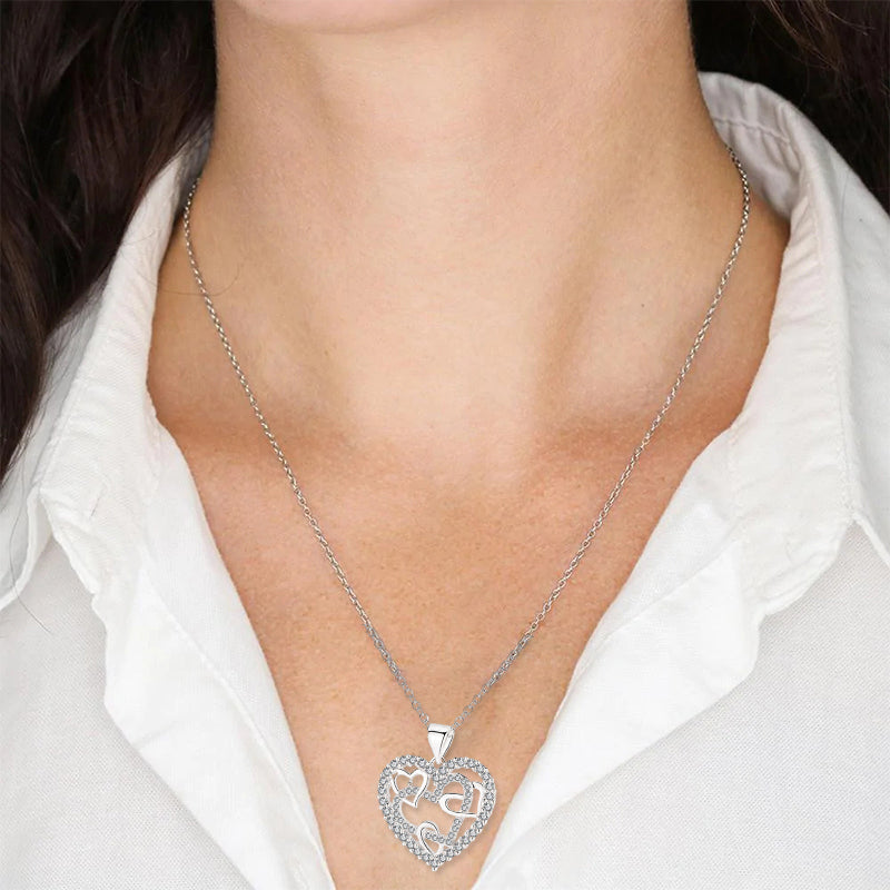 Dubbelhjärta halsband med gnistrande CZ-stenar, sammanlänkade hjärtan i roséguld och silver mot vit bakgrund.