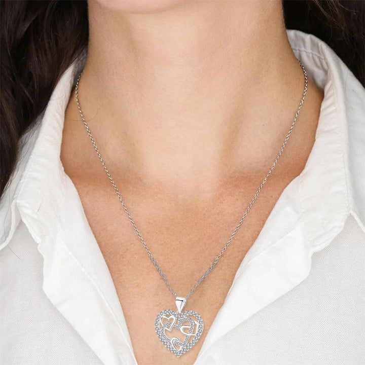 Dubbelhjärta halsband med gnistrande CZ-stenar, sammanlänkade hjärtan i roséguld och silver mot vit bakgrund.