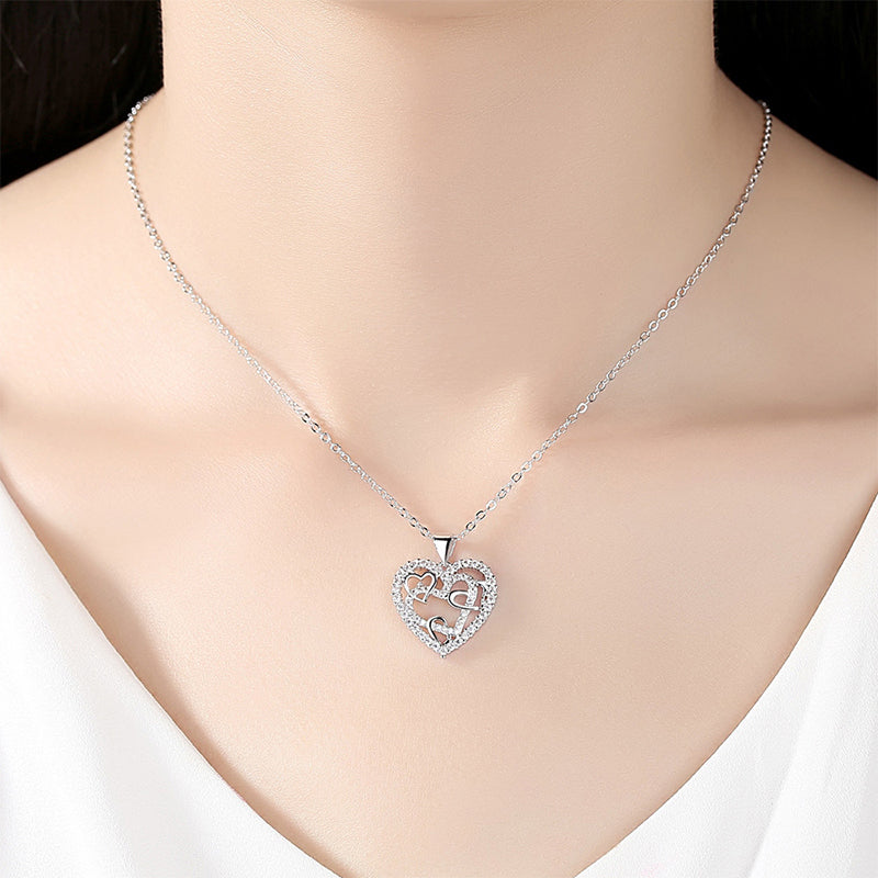 Dubbelhjärta halsband med gnistrande CZ-stenar, sammanlänkade hjärtan i roséguld och silver mot vit bakgrund.