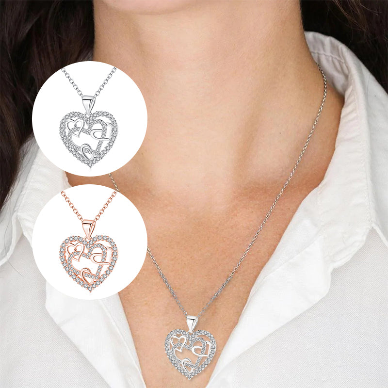 Dubbelhjärta halsband med gnistrande CZ-stenar, sammanlänkade hjärtan i roséguld och silver mot vit bakgrund.