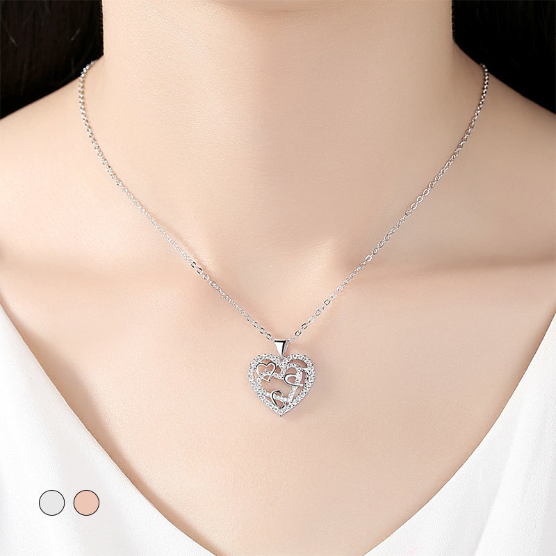 Dubbelhjärta halsband med gnistrande CZ-stenar, sammanlänkade hjärtan i roséguld och silver mot vit bakgrund.