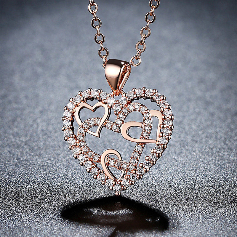 Dubbelhjärta halsband med gnistrande CZ-stenar, sammanlänkade hjärtan i roséguld och silver mot vit bakgrund.