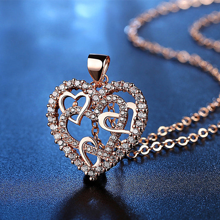 Dubbelhjärta halsband med gnistrande CZ-stenar, sammanlänkade hjärtan i roséguld och silver mot vit bakgrund.