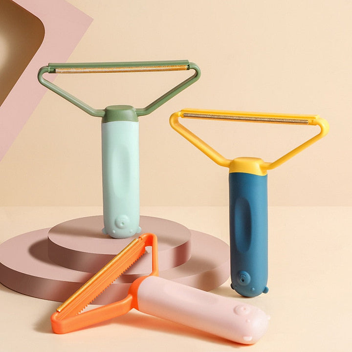 "Dubbelsidig luddskrapa i grön, ergonomisk design, effektiv för kläder, möbler och mattor, med mångsidig funktion."