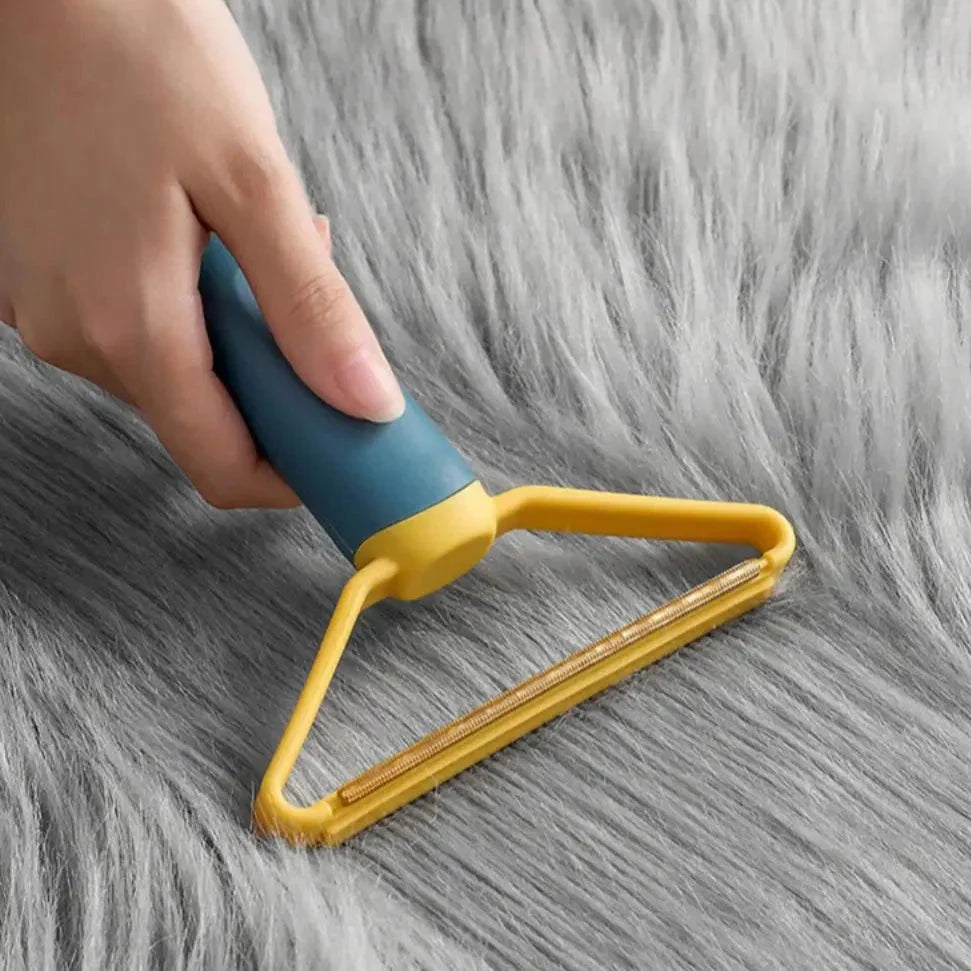 "Dubbelsidig luddskrapa i grön, ergonomisk design, effektiv för kläder, möbler och mattor, med mångsidig funktion."