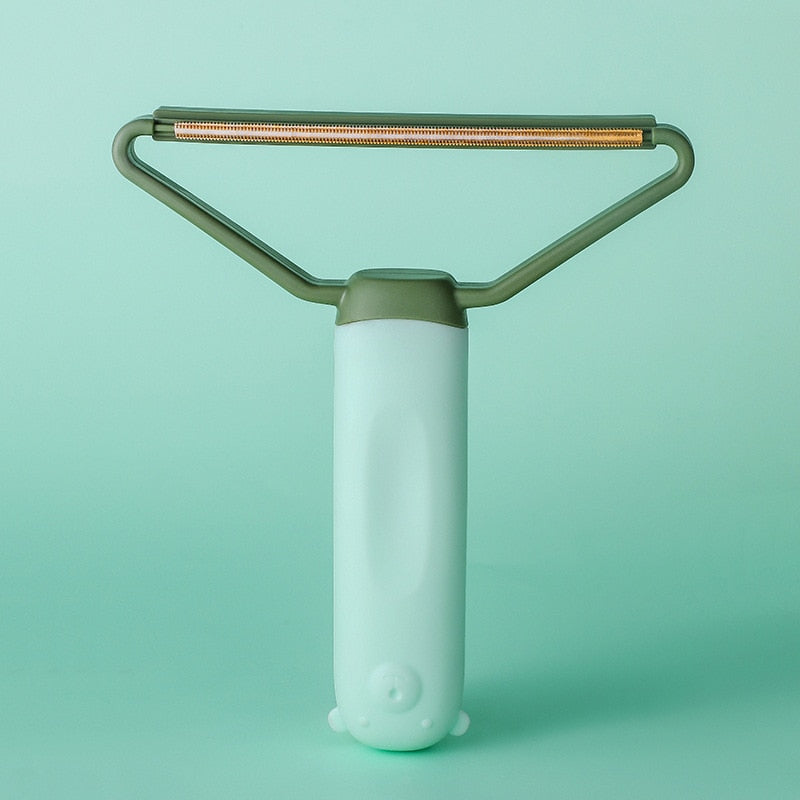 "Dubbelsidig luddskrapa i grön, ergonomisk design, effektiv för kläder, möbler och mattor, med mångsidig funktion."