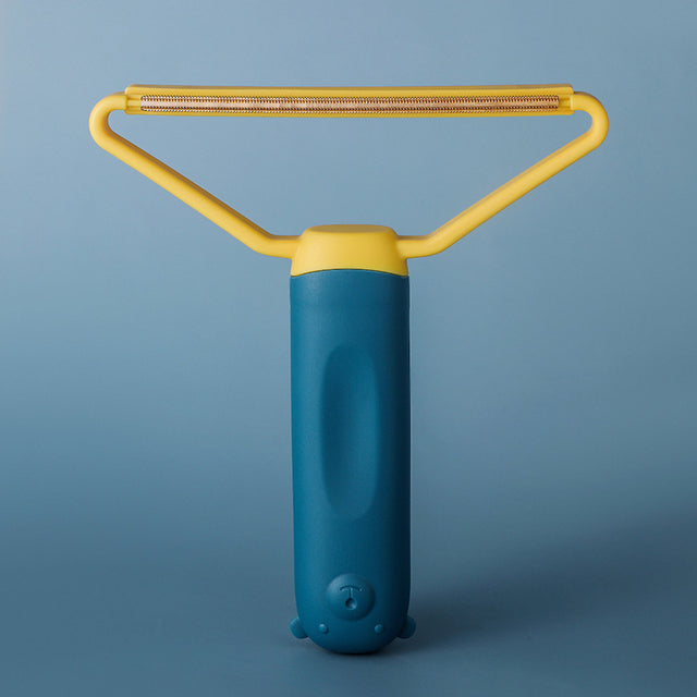 "Dubbelsidig luddskrapa i grön, ergonomisk design, effektiv för kläder, möbler och mattor, med mångsidig funktion."