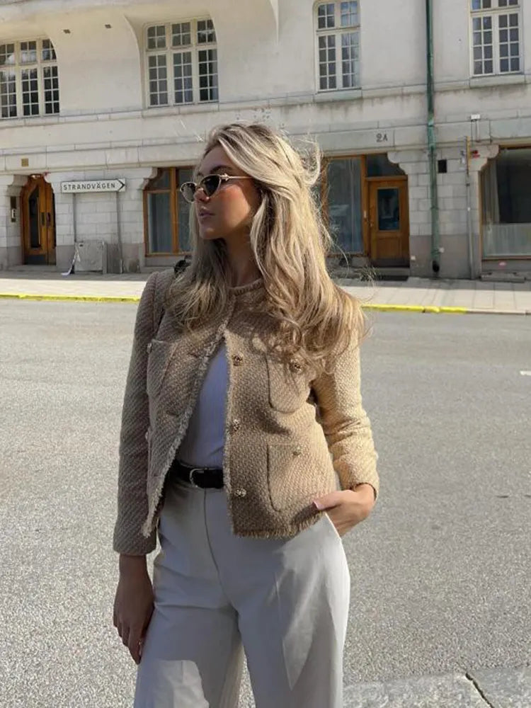 "Elegant beige tweedjacka för kvinnor, Luna, med guldglänsande detaljer och klassisk design. Perfekt för alla tillfällen."