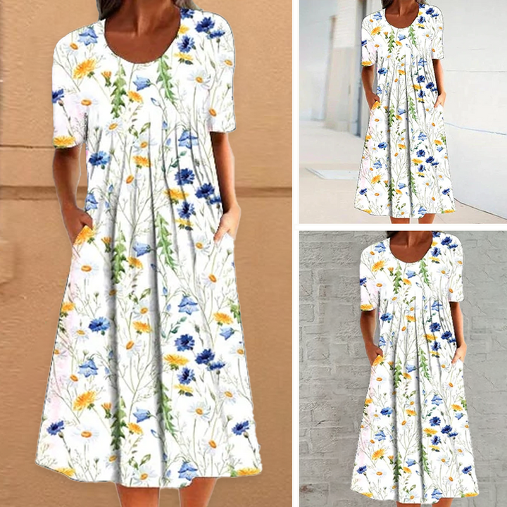 "Elegant blommig A-linje sommarklänning med rund hals i vitt, blått och gult, perfekt för sommardagar och fester."