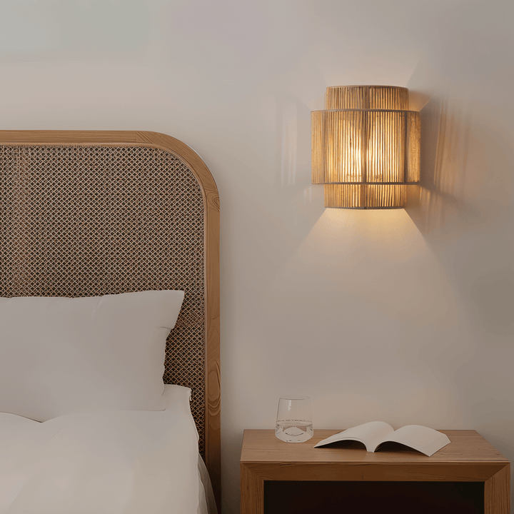 "Elegant boho hampavägglampa med rottingdetaljer, handgjord design som ger ett lugnande sken och naturlig atmosfär."