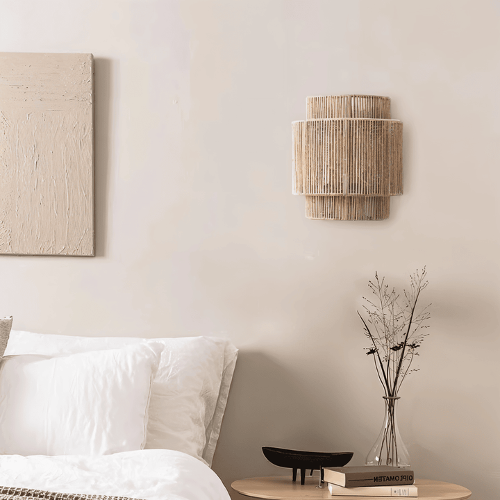 "Elegant boho hampavägglampa med rottingdetaljer, handgjord design som ger ett lugnande sken och naturlig atmosfär."
