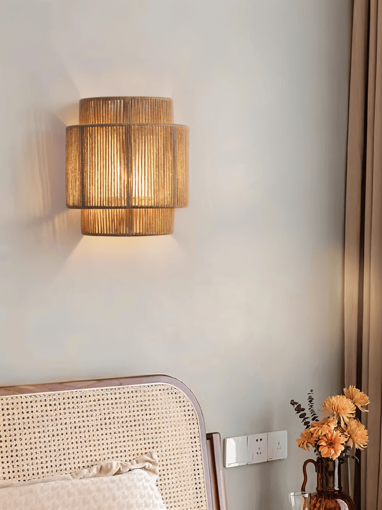 "Elegant boho hampavägglampa med rottingdetaljer, handgjord design som ger ett lugnande sken och naturlig atmosfär."