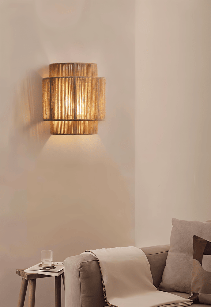 "Elegant boho hampavägglampa med rottingdetaljer, handgjord design som ger ett lugnande sken och naturlig atmosfär."