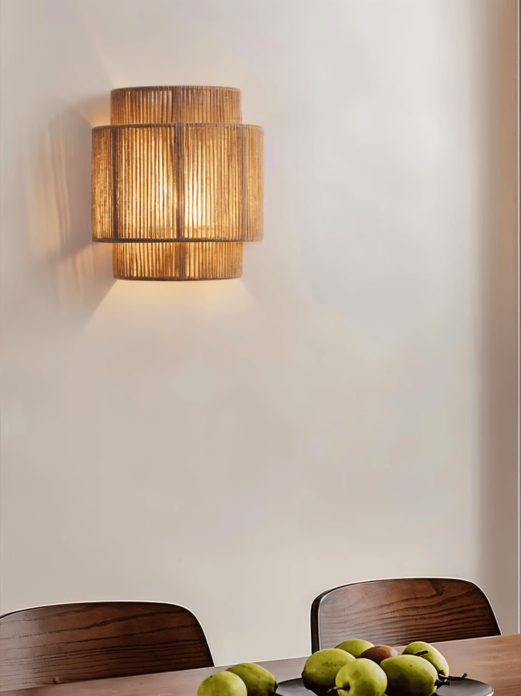 "Elegant boho hampavägglampa med rottingdetaljer, handgjord design som ger ett lugnande sken och naturlig atmosfär."