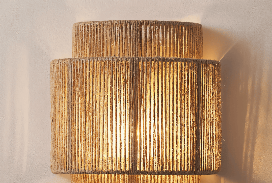 "Elegant boho hampavägglampa med rottingdetaljer, handgjord design som ger ett lugnande sken och naturlig atmosfär."