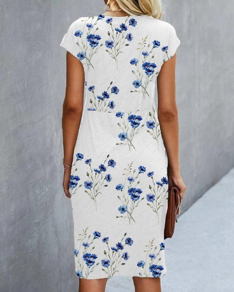 "Elegant damklänning med blommigt mönster, rund hals, capärm, figurnära, perfekt för sommarfest, knälång."