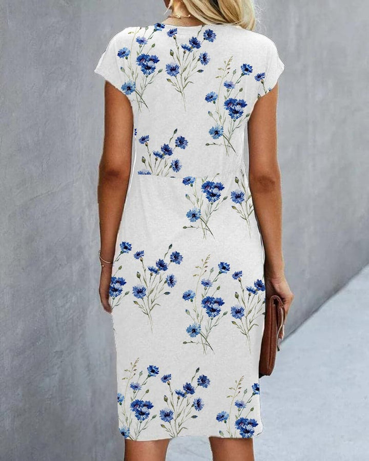 "Elegant damklänning med blommigt mönster, rund hals, capärm, figurnära, perfekt för sommarfest, knälång."