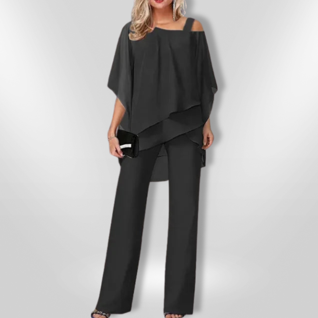 "Elegant damset med svart asymmetrisk topp och vida byxor som kombinerar stil och komfort för sofistikerade tillfällen."