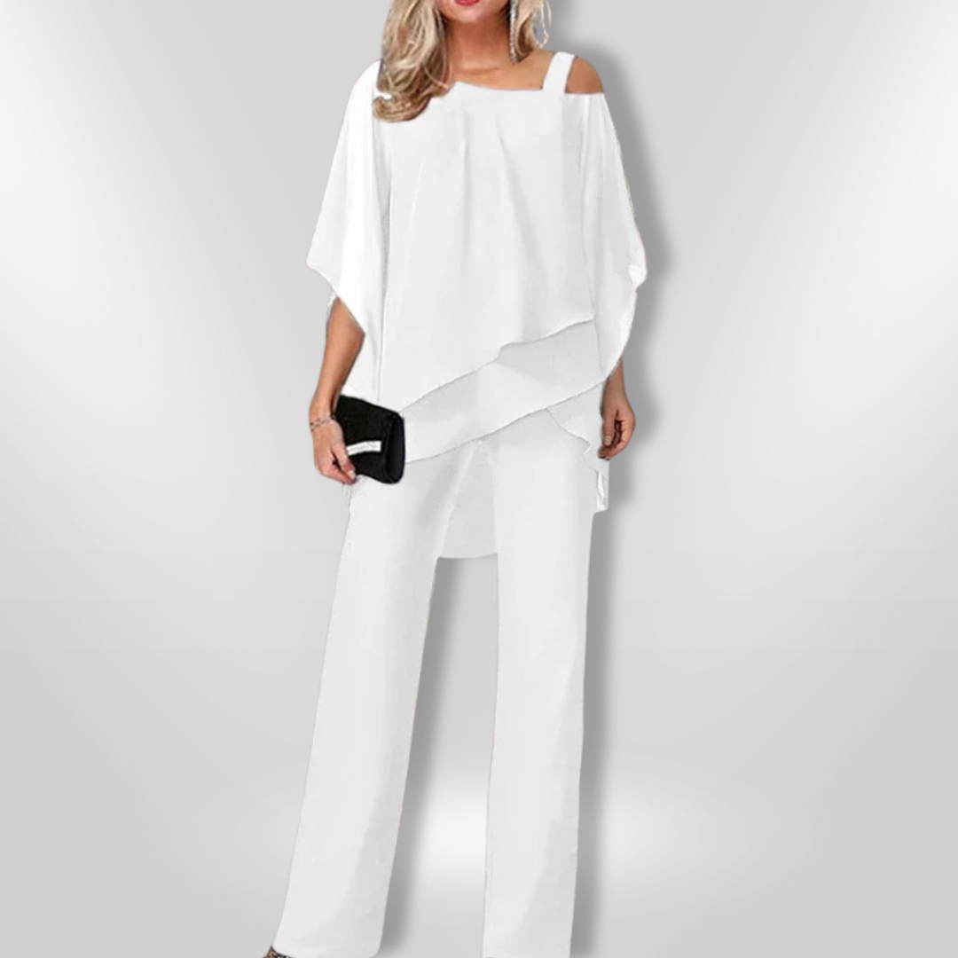 "Elegant damset med svart asymmetrisk topp och vida byxor som kombinerar stil och komfort för sofistikerade tillfällen."