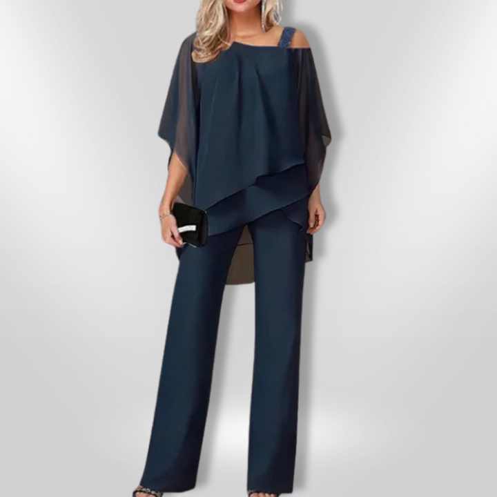 "Elegant damset med svart asymmetrisk topp och vida byxor som kombinerar stil och komfort för sofistikerade tillfällen."