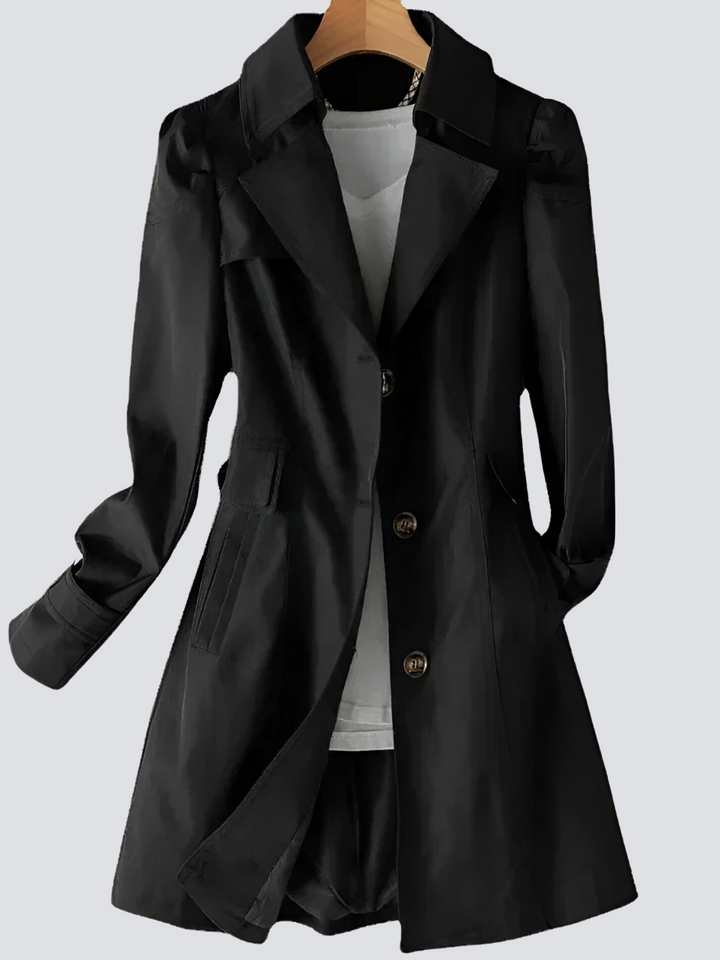 "Elegant damtrenchcoat i midi-längd med knappar, perfekt för höst/vinter. Visad i svart, långärmad, casual stil."