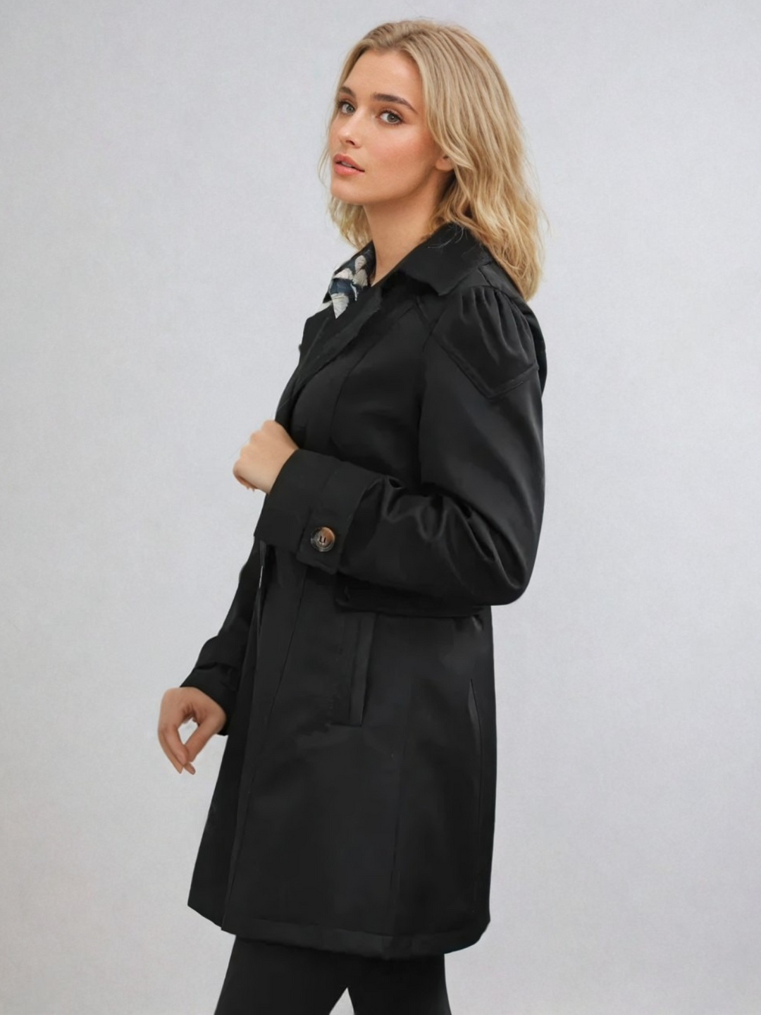 "Elegant damtrenchcoat i midi-längd med knappar, perfekt för höst/vinter. Visad i svart, långärmad, casual stil."