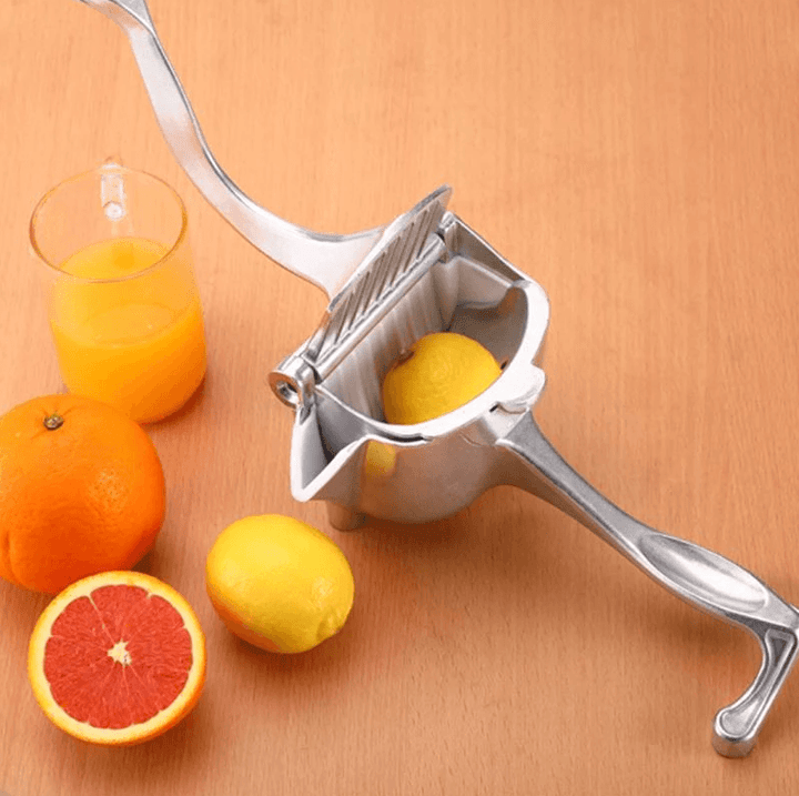"Elegant fruktjuicepress i glänsande rostfritt stål med rymlig skål, idealisk för färskpressad juice i köket."
