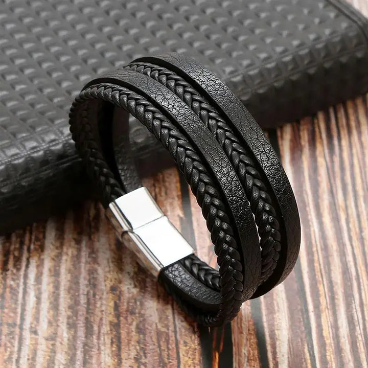 "Elegant herrarmband i flätad läderstil med graveringsbar detalj och magnetlås, perfekt som personlig accessoar."