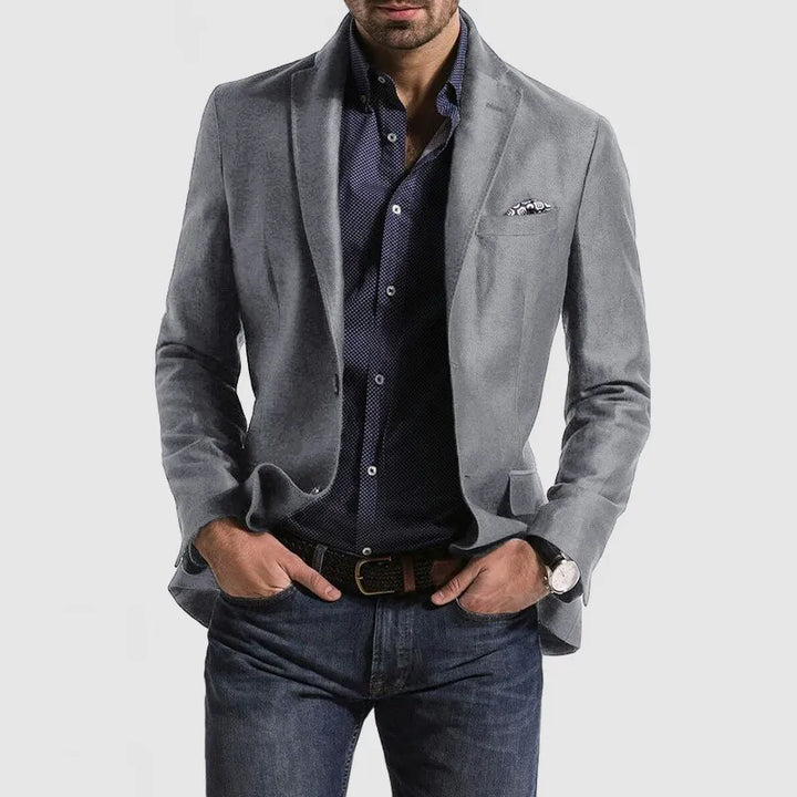 "Elegant herrblazer med tidlös design, mörkgrå färg, lång ärm, på modell, stilfullt sofistikerad look."