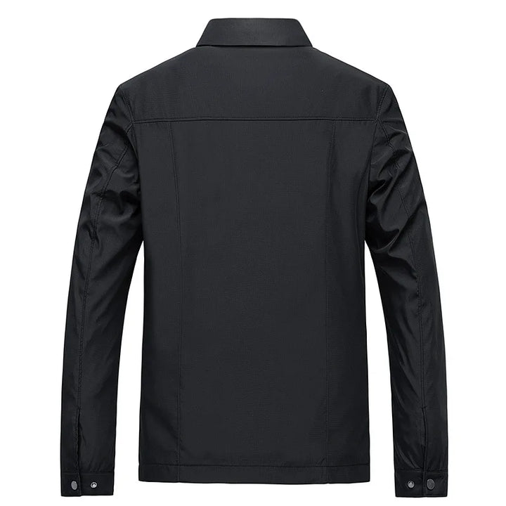 "Elegant herrjacka i vattenavvisande material, tidlös design, stilren mot blå bakgrund, passande för stadsliv."