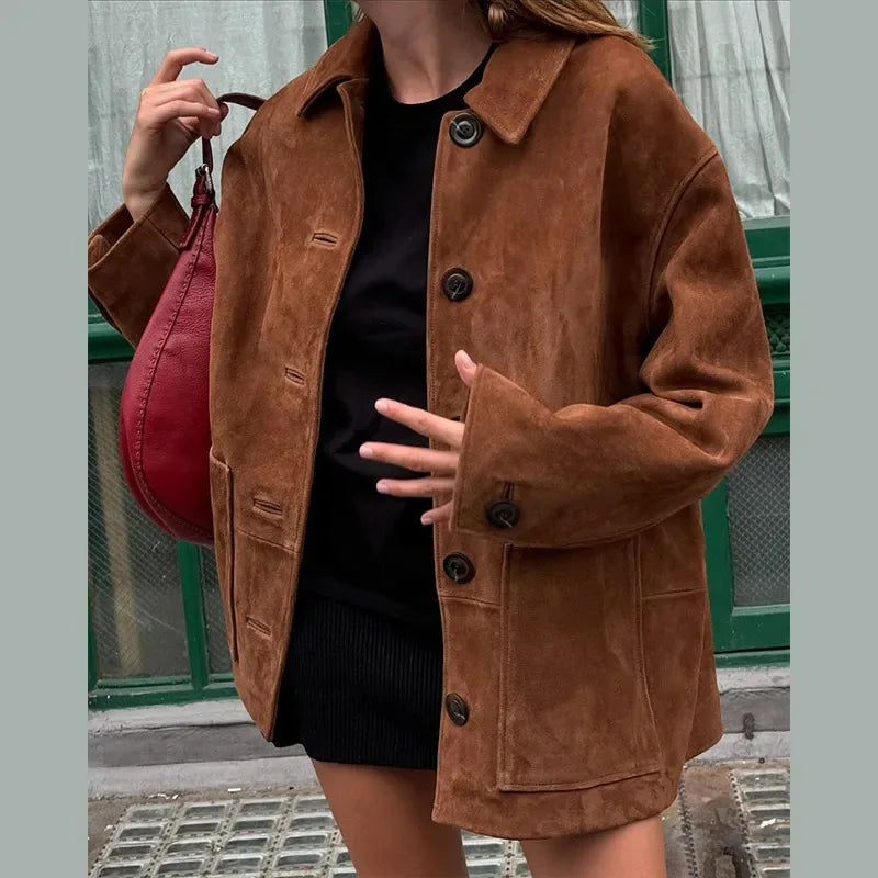 "Elegant jacka i brun fuskmocka, tidlös design med knappdetaljer, perfekt för sofistikerad och mångsidig stil."