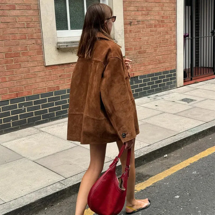 "Elegant jacka i brun fuskmocka, tidlös design med knappdetaljer, perfekt för sofistikerad och mångsidig stil."