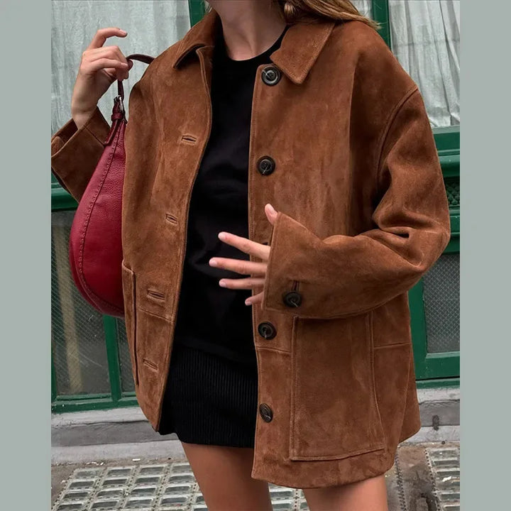 "Elegant jacka i brun fuskmocka, tidlös design med knappdetaljer, perfekt för sofistikerad och mångsidig stil."